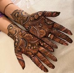 two hands with henna tattoos on them