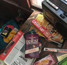 an old radio sitting on top of a wooden table next to magazines and other items