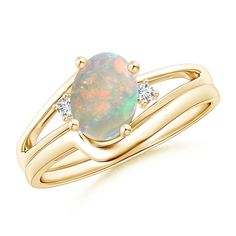 a gold ring with an opal and diamond set in the middle, on top of it