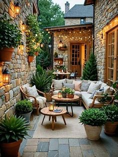 an outdoor living area with couches, tables and potted plants