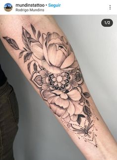 a black and white flower tattoo on the arm