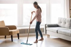 a woman is cleaning the floor with a mop