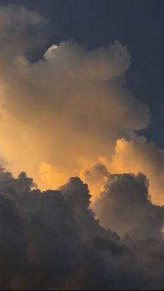 an airplane is flying through the clouds at sunset