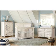 a baby's room with blue walls and white furniture