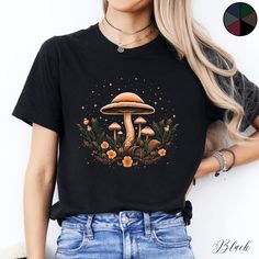 Mushroom Flowers and Stars Unisex Tee Shirt | Cottagecore Clothing | Botanical Boho Tshirt | Goblincore Aesthetic Clothes  ✔️ Soft, light and comfortable unisex short sleeve tee ✔️ 100% Airlume combed and ringspun cotton (fiber content may vary for different colours*) ✔️ Light fabric (4.2 oz/yd² (142 g/m ✔️ Retail fit 📏 Runs true to size ✔️ Dual side seams for structural support of the garment help hold its shape longer ✔️ Ribbed knit elastic collars to bolster shaping, twill taped shoulders to Black Crew Neck T-shirt With Plant Print, Black Short Sleeve Top With Mushroom Print, Fall Mushroom Design Crew Neck T-shirt, Fall Crew Neck T-shirt With Mushroom Design, Mushroom Print Graphic Tee With Crew Neck, Mushroom Print Crew Neck Graphic Tee, Black Graphic Tee With Mushroom Print, Fall Crew Neck T-shirt With Mushroom Print, Black Crew Neck T-shirt With Mushroom Print