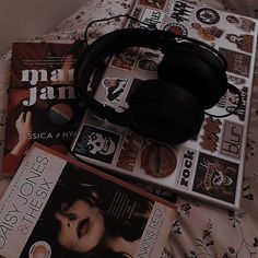 some books and headphones on a bed