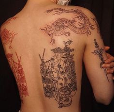 the back of a woman's body with tattoos on it