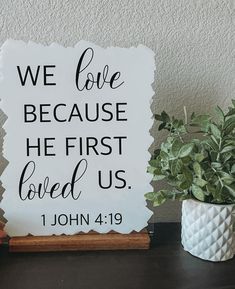 a sign that says, we love because he first loved us john 4 19 on it