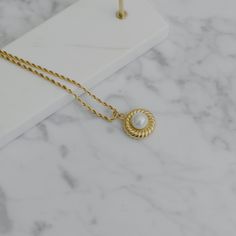 "A feminine and Parisian styled necklace, designed with twist details. Beautiful gold finish. This necklace is a perfect statement for your daily outfits. - Materials: 18K gold plated titanium and acrylic pearl - Measurements: the charm is approximately 0.85\" / 2.2cm in diameter - Length: approximately 18\" / 46cm in total length with 2\" / 5cm extension - The product is tarnish-resistant and hypoallergenic Q&A 1. What is the material? - It is made from 18K real gold plated titanium. Titani Elegant Rope Chain Necklace With Round Pendant, Elegant Necklace With Rope Chain And Round Pendant, Elegant White Rope Chain Necklace, Stacked Necklaces, Hypoallergenic Jewelry, Gold Snake, Rope Necklace, Pearl Pendant Necklace, Pearl Pendant