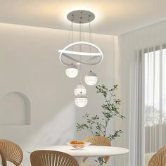 a white table with four chairs around it and a vase on the table next to it