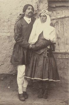 an old photo of two people standing next to each other