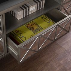 a book shelf with several books on top of it and two stacks of cards in the bottom drawer