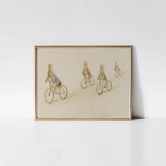 three rabbits riding on bicycles in the sand