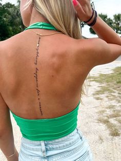 the back of a woman's neck with writing on her left shoulder and right arm