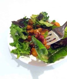 a white plate topped with salad and a fork