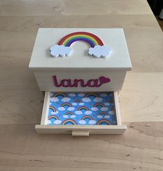 a wooden box with a rainbow and clouds on it