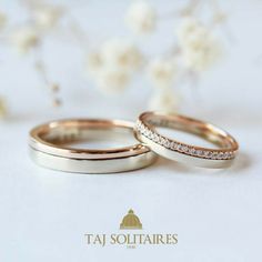 two gold wedding bands with white diamonds on the top and bottom, sitting next to each other