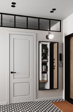 an empty room with black and white flooring, two doors open to the bathroom