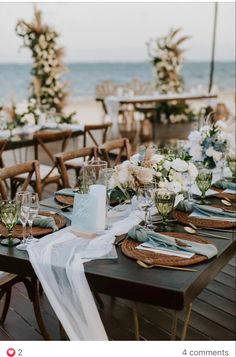 a table set up with place settings and flowers on it for an outdoor wedding reception