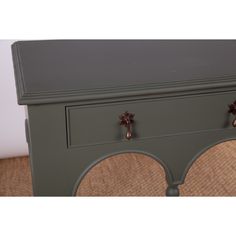 an old dresser with two drawers and knobs on the top, is painted green