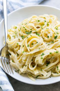 a white plate topped with pasta and parsley