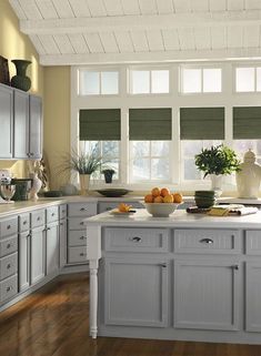 a kitchen filled with lots of counter top space next to a window covered in blinds