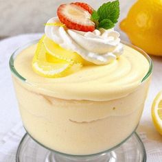 a dessert with lemons, strawberries and whipped cream in a small glass dish