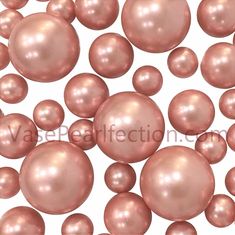 many pink pearls are scattered together on a white background