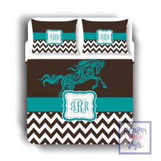 a bed with brown and teal chevrons, blue monogrammed horse on it