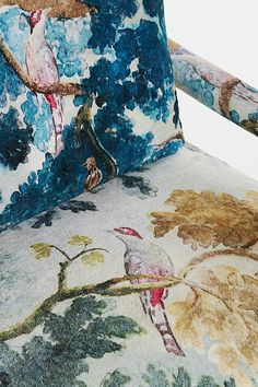 an upholstered chair with a bird design on it