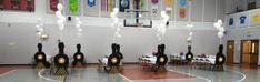 an indoor basketball court decorated with balloons and streamers