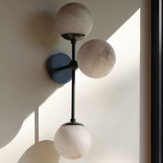 three light fixtures hanging from the side of a wall