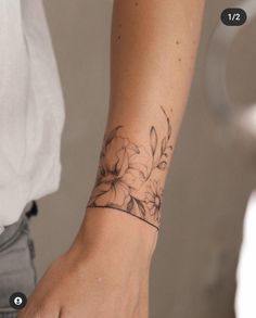 a woman's arm with a flower tattoo on the left side of her wrist