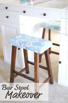 two stools sitting in front of a kitchen counter with a sink and cabinets behind them