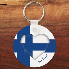 a heart shaped keychain with the flag of finland painted on it's side