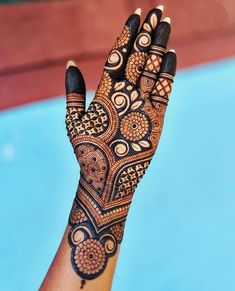 a woman's hand with henna tattoos on it