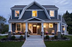 a gray house with two front porches and steps leading up to the front door