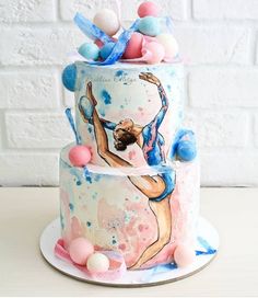 a three tiered cake decorated with pink, blue and white icing