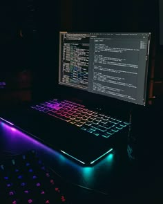 a laptop computer sitting on top of a desk next to a keyboard and mouse pad