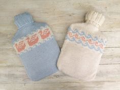 two knitted mittens sitting next to each other on a wooden floor, one with an orange and blue design