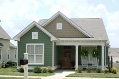 a green house with white trim and two porches