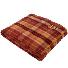 an orange and brown plaid blanket on a white background