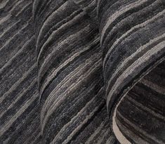 a close up view of the back end of a gray and black striped couch cushion