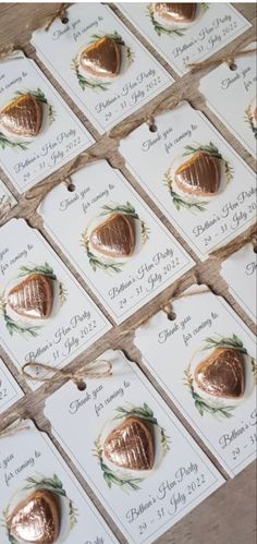 a table topped with lots of cards covered in gold foiled eggs on top of twine