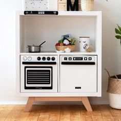 a white stove top oven sitting next to a potted plant