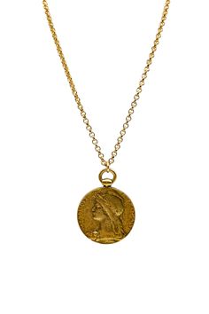 a gold necklace with a coin on it