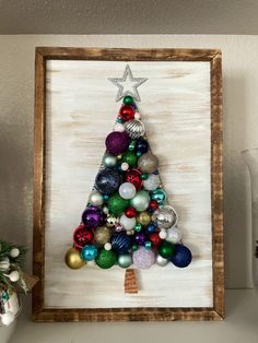 a christmas tree made out of ornaments in a wooden frame