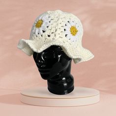 a white crocheted hat on top of a mannequin head