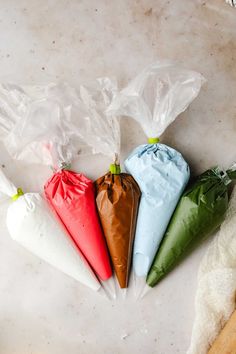 four bags filled with food sitting on top of a white counter next to a knife