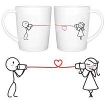 two coffee mugs with stick figures on them, one holding a heart and the other looking